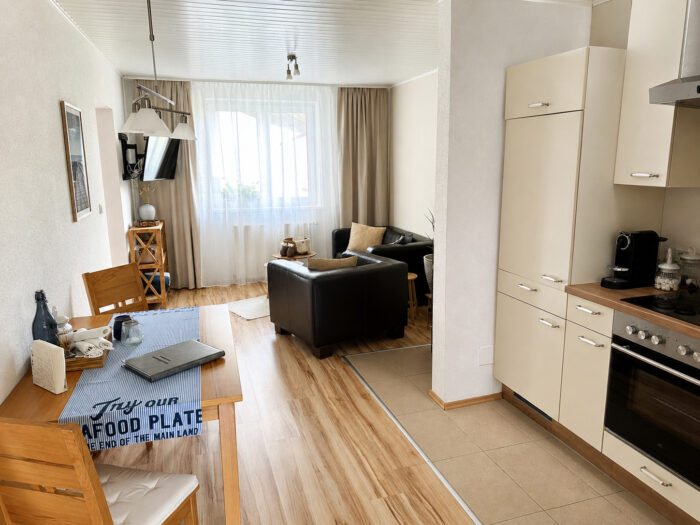 Svetlý, bezbariérový obývací priestor v rekreačnom apartmáne v Gutenbrunne s otvorenou kuchyňou, jedálenským kútom a útulným posedením, ideálny na rodinnú dovolenku.
