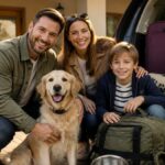 checkliste-fur-den-ersten-urlaub-mit-hund-1792215541 - Ferienwohnungen Gutenbrunn Happy family of three and their golden retriever posing beside an open car trunk filled with luggage, ready for a road trip.